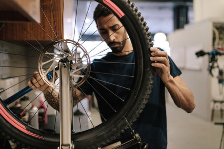 Mechanic repairing a bicycle in workshop
