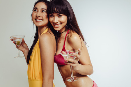 Smiling women in swimsuit with cocktail