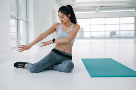 Woman rehearsing yoga poses at fitness studio