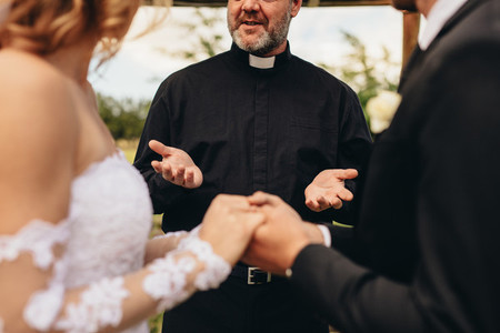 Priest giving blessings to bride and groom