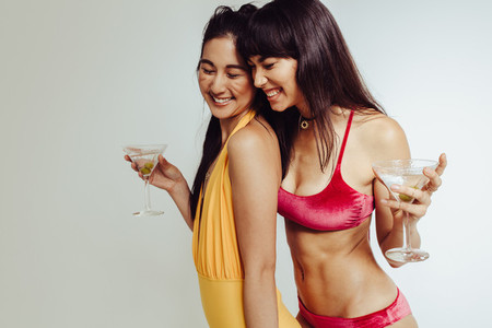 Smiling female friends with cocktails