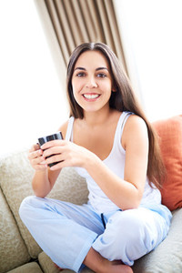 Woman relaxing on couch with a warm drink