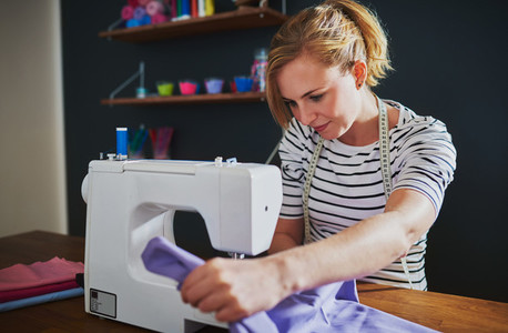 Young fashion designer using a sewing machine