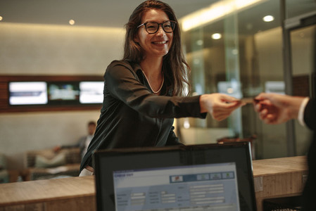 Business woman receiving key card for hotel room