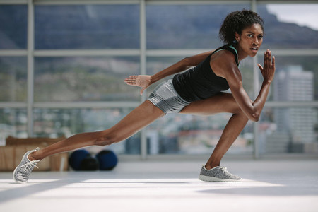 Slim african woman exercising in gym