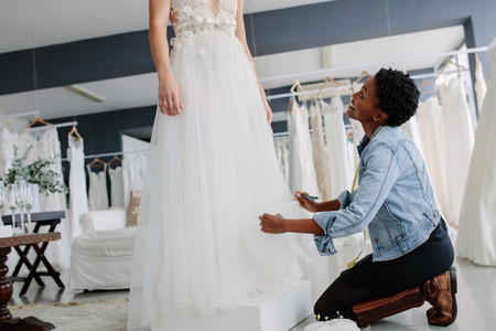 Smiling woman making adjustment to bridal gown
