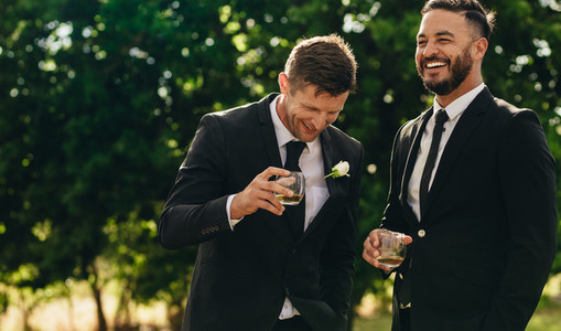 Groom and best man drinking at wedding party