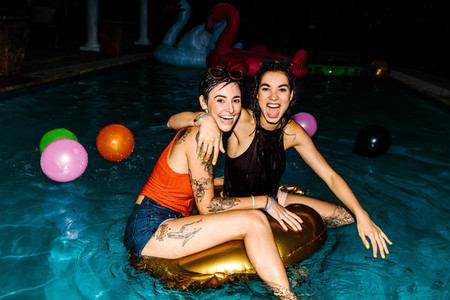 Female friends enjoying evening pool party