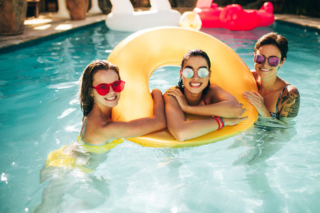 Cheerful women in pool with inflatable ring