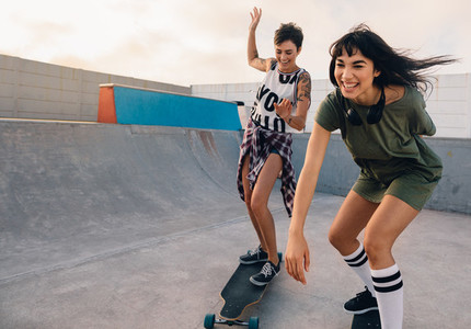 Girls riding on skateboards and having fun at skate park