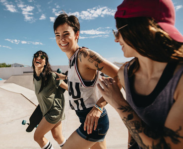 Women friends running outdoors at skate park