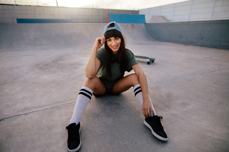 Attractive urban girl sitting relaxed at skate park