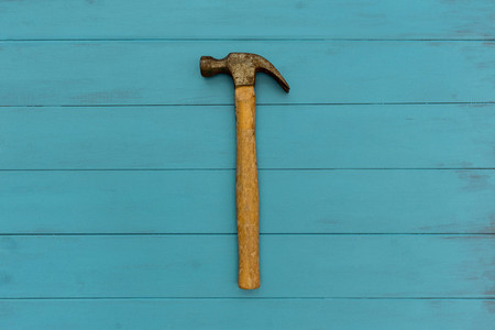 Old hammer on wood texture background
