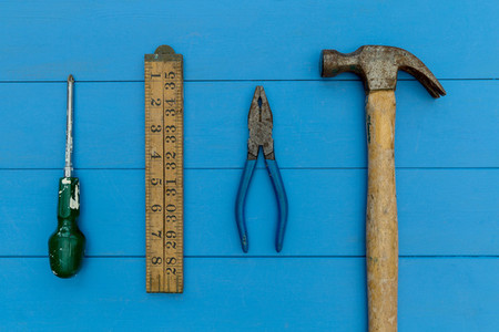 Old hammer and DIY tools on wood background
