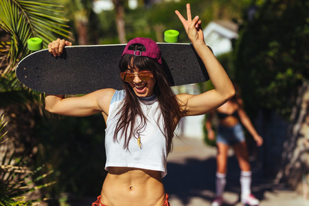 Stylish woman on summer vacation with skateboard