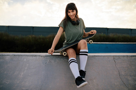 Cool woman skateboarder at skate park