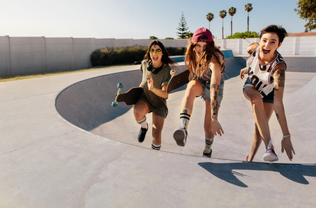 Laughing women climbing a skateboard ramp