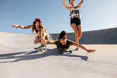 Women riding skateboards and having fun at skate park