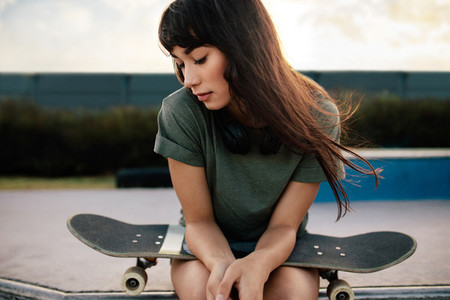 Female skateboarded relaxing at skate park