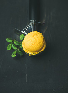 Mango sorbet ice cream scoop in ice cream scooper