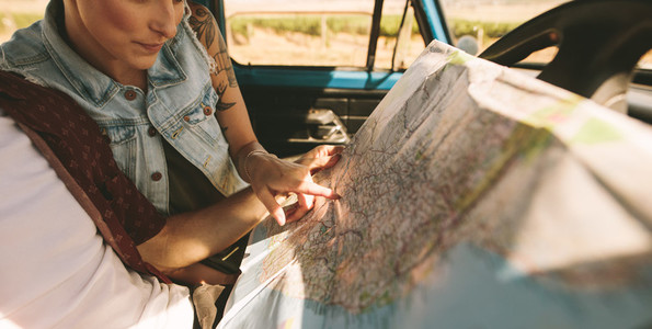 Young travellers on a road trip looking at map