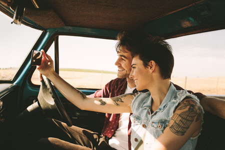 Young couple on a road trip driving in car