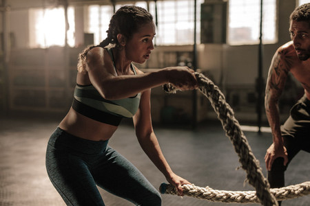 Female exercising with battle ropes