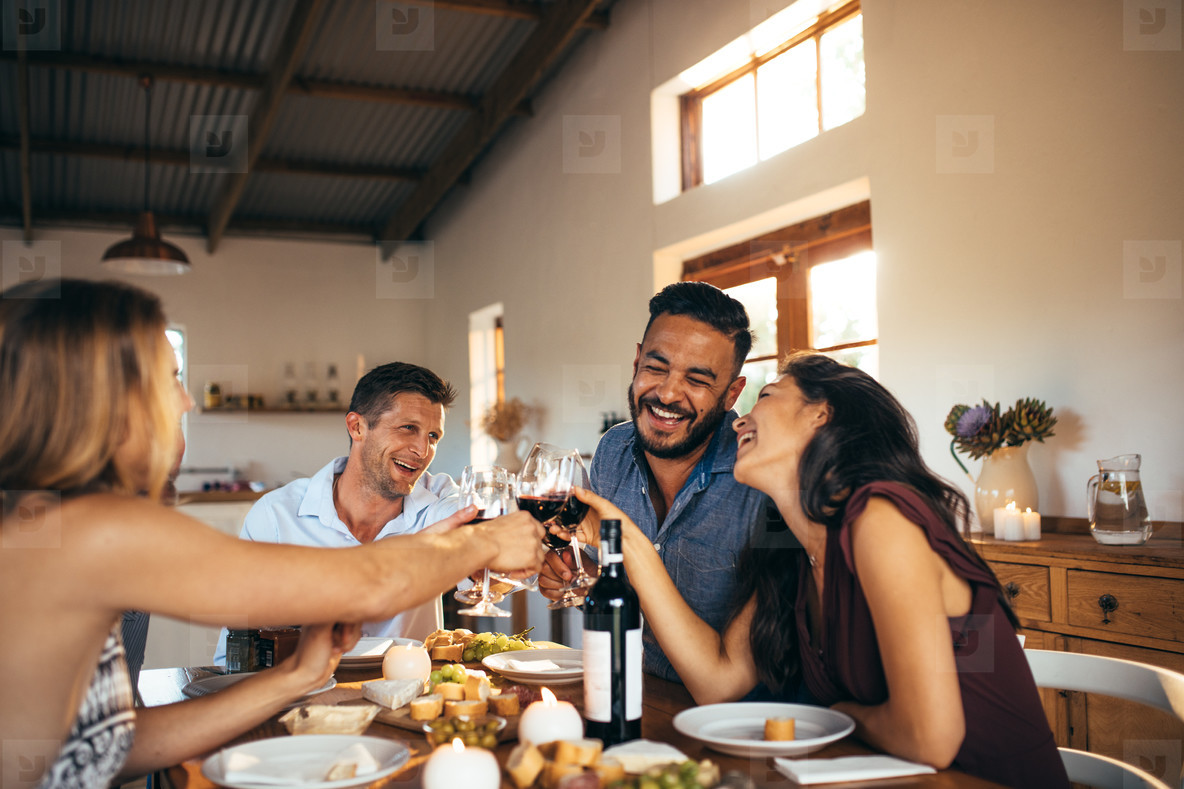 Friends enjoying home party with drinks and jokes