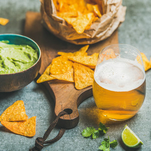 Mexican corn chips fresh guacamole sauce and beer square crop