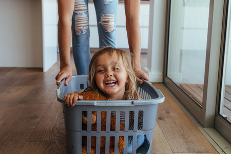 Little girl and her mother having fun doing laundry
