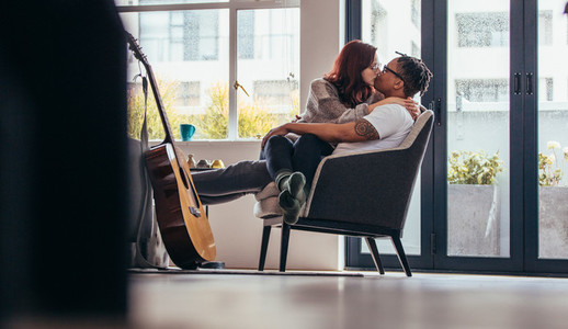 Romantic interracial couple kissing at home