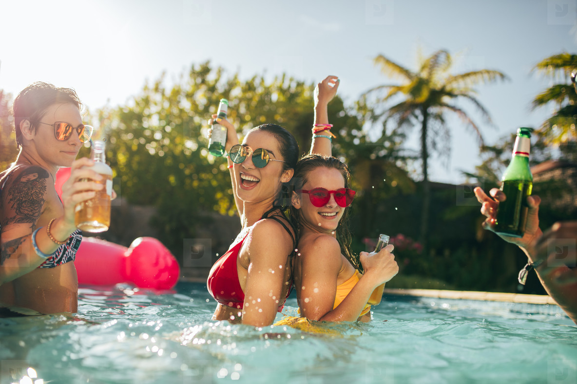 Happy friends enjoying in swimming pool party