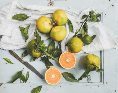 Fresh Turkish tangerines with leaves over blue rustic wooden backdrop