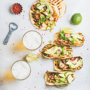 Healthy corn tortillas with chicken avocado salsa limes and beer