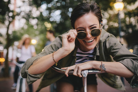 Cheerful woman in sunglasses with bike