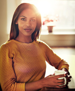 Calm black woman sitting at table with bright sun