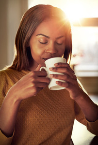 Attractive young woman savoring a cup of coffee