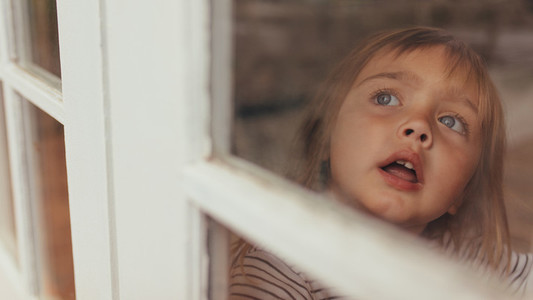 Little girl sitting by the window