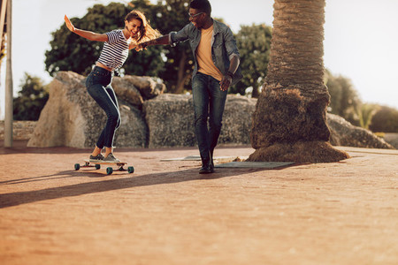Woman learning to ride skateboard