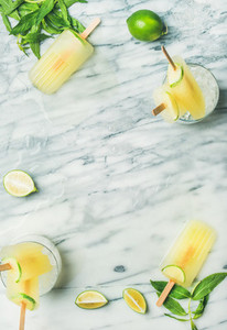 Summer refreshing lemonade popsicles with lime and mint leaves
