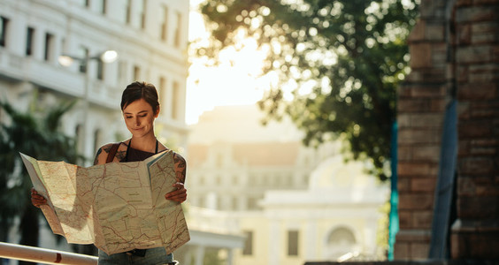 Woman standing outdoors holding a map