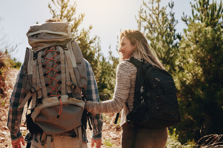 Couple with backpacks hiking on mountain
