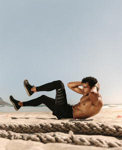 Man doing abdomen workout at the beach