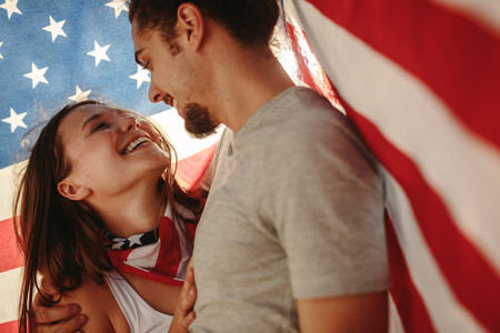 Affectionate couple under American flag
