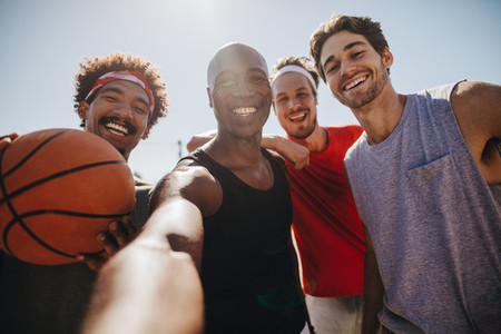 Men playing basketball posing for photo