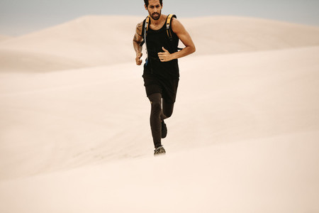 Man running on sand dunes