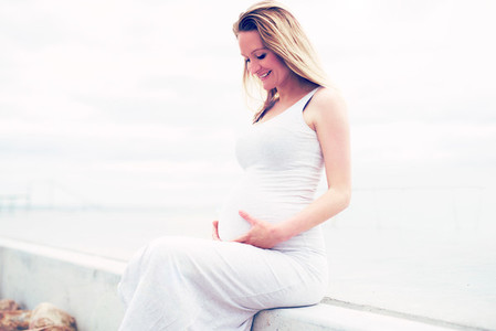 Happy pregnant woman bonding with her unborn child