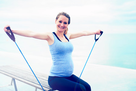 Pregnant woman exercising with ropes