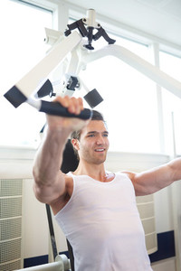 Muscular Guy Doing Chest Press Exercise in the Gym