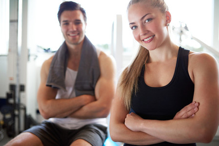 Fit Couple Smiling at Camera with Arms Crossed